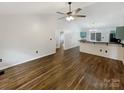 An expansive living room leads into the kitchen, showcasing hardwood floors and a vaulted ceiling complete with a ceiling fan at 121 Purple Finch Ln, Mooresville, NC 28117