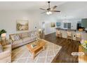 Bright living room seamlessly connects to the kitchen, boasting stylish furnishings and a vaulted ceiling with a ceiling fan at 121 Purple Finch Ln, Mooresville, NC 28117