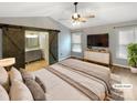 A serene main bedroom featuring a sliding barn door to the bathroom, a ceiling fan, and a large window for natural light at 121 Purple Finch Ln, Mooresville, NC 28117