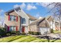 Charming two-story home with brick accents, red shutters, and a well-manicured lawn at 16207 Hollingbourne Rd, Huntersville, NC 28078