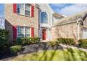 Inviting front entrance with a bright red door, decorative wreath, and well-kept landscaping at 16207 Hollingbourne Rd, Huntersville, NC 28078