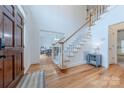 Inviting foyer featuring gleaming hardwood floors, a staircase, and a view into the adjacent dining room at 2800 Providence Hills Dr, Matthews, NC 28105