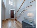 Bright and airy foyer with hardwood floors, a staircase, and a high window letting in natural light at 2800 Providence Hills Dr, Matthews, NC 28105