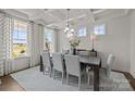 Elegant dining room with large windows, chandelier, table with seating for six at 281 Supernova Dr, York, SC 29745