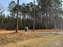 Picturesque property showcasing wooded land, a gravel driveway, and easy access to utilities at 339 Pine Lake Dr # 760, Troy, NC 27371