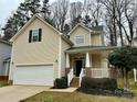 Two-story home with a well-maintained lawn, attached garage, and welcoming front porch at 4809 Canipe Dr, Charlotte, NC 28269