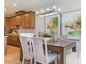 Dining area with wood table, upholstered chairs, modern lighting, and decorative art at 5911 Wetlands Aly, Charlotte, NC 28215