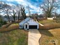 Aerial view of a modern home showcasing a long driveway, fenced-in backyard, and manicured lawn at 713 E Third Ave, Gastonia, NC 28054