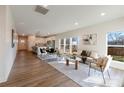 Bright open concept living room with wood floors flowing into the kitchen with a dining area and large windows at 713 E Third Ave, Gastonia, NC 28054