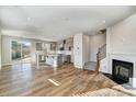 Bright living room featuring hardwood floors, a fireplace, an island kitchen, and rear patio access at 8023 Downy Oak Ln, Charlotte, NC 28269