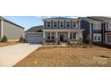 Beautiful two-story home with stone accents, a welcoming porch, and an attached two-car garage at 845 Regulus Ct, York, SC 29745