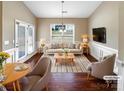 Bright living room features hardwood floors, neutral colors, and large windows with plenty of natural light at 8804 Artesa Mill Ln, Charlotte, NC 28214