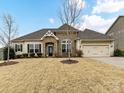 Charming ranch-style home featuring a stone-accented entrance, manicured lawn, and attached two-car garage at 10094 Dressage Ln, Midland, NC 28107