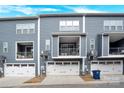 Townhome showcasing a well-maintained exterior with gray siding, balconies, and garages at 112 August Ln, Matthews, NC 28104