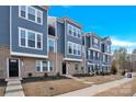 Townhome showcasing a well-maintained exterior with blue siding and brick accents at 112 August Ln, Matthews, NC 28104