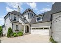 Beautiful white brick home with a well-manicured lawn, a dark roof and an attached two-car garage at 1328 S Kings Dr, Charlotte, NC 28207