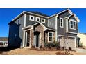 Charming two-story home with stone facade, gray siding, and attached two-car garage at 1463 Honey Trl, Monroe, NC 28112