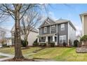 Charming two-story home with gray siding, well-manicured landscaping, and covered porch at 17436 Harbor Walk Dr, Cornelius, NC 28031