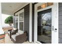 Charming covered porch with seating area, views of the neighborhood, and stylish front door at 17436 Harbor Walk Dr, Cornelius, NC 28031