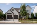 Charming two-story home featuring a manicured front lawn, black fencing, and a two-car garage at 2016 Thatcher Way, Fort Mill, SC 29715