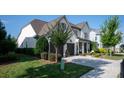 Elegant white brick home featuring a manicured front lawn, black fencing, and a convenient two-car garage at 2016 Thatcher Way, Fort Mill, SC 29715