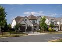 Elegant white brick home with a manicured front lawn, black fencing, and a convenient two-car garage at 2016 Thatcher Way, Fort Mill, SC 29715