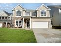 Two-story home boasts a stone facade, balcony, manicured lawn, two car garage and inviting curb appeal at 2024 Woodshorn Dr, Matthews, NC 28104