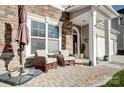 Cozy front porch with stone accents and comfortable seating for relaxing outdoors at 2024 Woodshorn Dr, Matthews, NC 28104