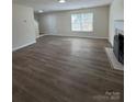 Spacious living room with wood floors, a fireplace, and ample natural light at 2303 Hope Valley Ln, Charlotte, NC 28213