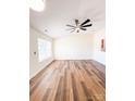 Spacious living room featuring wood-look flooring, natural light and fan at 2307 Hope Valley Ln, Charlotte, NC 28213