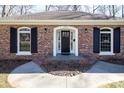 Inviting front entrance with brick facade, black door, and white trim with new walkway at 4501 Pine Valley Rd, Charlotte, NC 28210