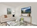 Bright living room with a comfortable beige sofa, modern decor, and large windows providing ample natural light at 5156 Fireweed Ct, Dallas, NC 28034