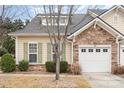 Charming home featuring a stone facade, white garage door, and nicely manicured landscaping at 526 Pine Links Dr, Tega Cay, SC 29708
