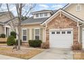 View of home showing stone accents, light siding, a white garage door, and tidy landscaping at 526 Pine Links Dr, Tega Cay, SC 29708