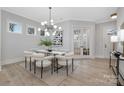 Bright dining room featuring a modern light fixture, neutral walls, and a glass-topped dining table at 600 Campus St, Charlotte, NC 28216