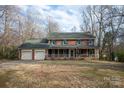 Charming two-story brick home with a covered front porch and a two-car garage, perfect for Gathering living at 7210 Timber Ridge Dr, Mint Hill, NC 28227