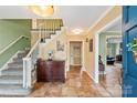 Welcoming foyer with tile flooring, a staircase, and warm, neutral paint colors at 7210 Timber Ridge Dr, Mint Hill, NC 28227