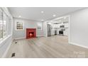Bright living room with a red-painted fireplace, connecting seamlessly to a modern kitchen at 723 Wood St, Statesville, NC 28677