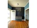 Bright entryway featuring wood floors, fresh paint, a sleek cabinet, and a glass storm door letting in natural light at 8508 Colgate Cir, Charlotte, NC 28214