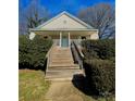 Inviting home with a large wooden staircase leading to the front door, surrounded by mature bushes and a walkway at 8508 Colgate Cir, Charlotte, NC 28214