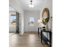 Bright foyer featuring wood-look flooring, modern light fixture, console table with mirror, and paneled accent walls at 889 Regulus Ct, York, SC 29745