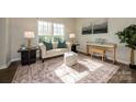 Sunlit living room featuring stylish sofa, piano, and decorative rug at 9031 Pembroke Ct, Indian Land, SC 29707