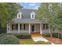 Inviting home featuring a classic front porch with columns, a well-maintained lawn, and dormer windows at 103 Patience Place Ln, Mooresville, NC 28117