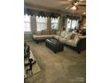 Inviting living room featuring neutral tones, plush carpeting, a cozy sectional sofa, and plenty of natural light at 10415 Plantain Ct, Charlotte, NC 28213