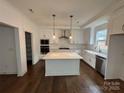 Modern kitchen with a center island, stainless steel appliances, and white cabinets at 107 Spring View Ln, Statesville, NC 28677