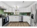 Stylish kitchen featuring white cabinets, stainless steel appliances, and green tile backsplash at 1075 Wellman St, Gastonia, NC 28054