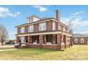 Charming brick home with a welcoming porch, mature trees, and a well-manicured lawn at 111 Bethpage Rd, Kannapolis, NC 28081