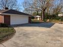Long concrete driveway leading to an attached garage and backyard basketball court at 1807 Brantley Rd, Kannapolis, NC 28083