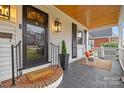 Inviting covered porch features rocking chairs and a brick trimmed entrance, enhancing curb appeal at 2840 Hillsdale Ave, Charlotte, NC 28209
