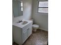 Clean bathroom featuring a white vanity, toilet, and neutrally patterned floor at 4161 Slanting Bridge Rd, Sherrills Ford, NC 28673